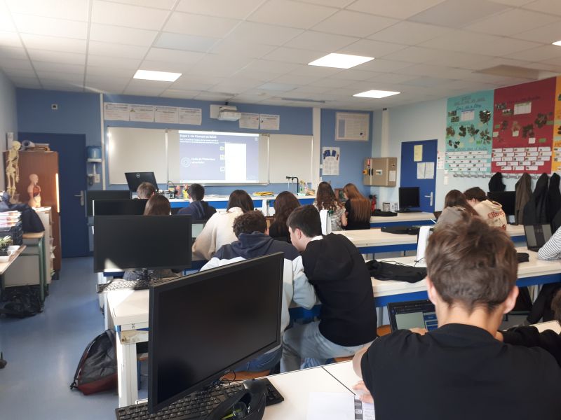 Eleves de dos dans une salle de classe, devant leurs ordinateurs
